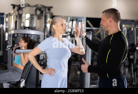 Felice donna anziana sportiva alta allenatrice in palestra Foto Stock