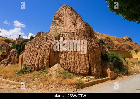 Casa-grotta troglodita a Guadix, Andalusia, nel sud della Spagna - abitazione sotterranea in un paesaggio desertico, scavata nelle colline fangose del Barr Foto Stock