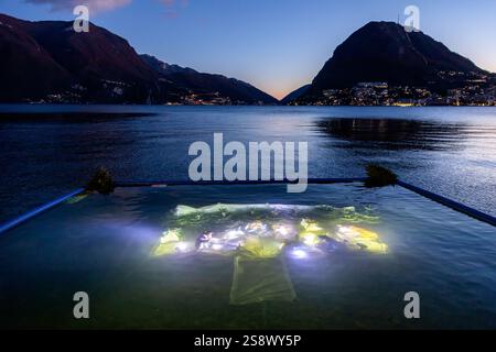Lugano, Svizzera - 22 dicembre 2024: Il presepe sommerso illuminato nel lago di Lugano la sera Foto Stock