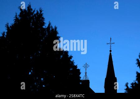 Ein Kreuz mit Wetterhahn steht auf dem Dach einer Kirche vor Abendhimmel. Der Kirchenaustritt ist die vom Bürger auf eigenen Wunsch veranlasste Beendigung der staatlich registrierten Mitgliedschaft in einer Kirche. Themenbild, Symbolbild Frechen, 23.01.2025 NRW Deutschland *** Una croce con un rubinetto si erge sul tetto di una chiesa contro il cielo serale lasciando la chiesa è la fine dell'appartenenza statale a una chiesa su richiesta dei cittadini immagine a tema, immagine simbolica Frechen, 23 01 2025 NRW Germania Copyright: XChristophxHardtx Foto Stock