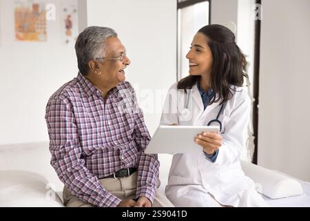 Giovane donna medico uomo in pensione paziente divertendosi con il tablet Foto Stock