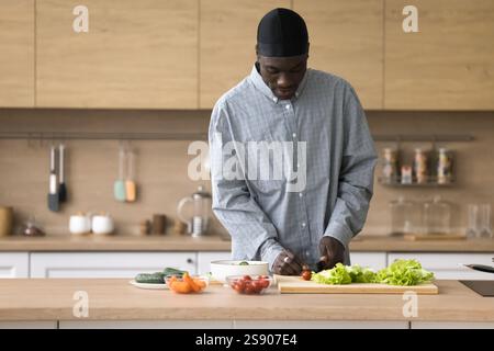Uomo afroamericano di mezza età impegnato a cucinare in cucina casalinga Foto Stock