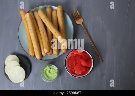 Colazione servita: Salsicce su un piatto con salsa bianca, zenzero sottaceto rosso e formaggio bianco, vista dall'alto. Concetto di auto veloce. Foto Stock