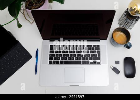 piatto di un computer portatile aperto con tazza, mouse, unità usb, penna e tablet Foto Stock
