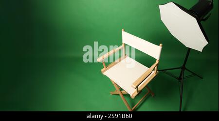 Studio fotografico con sfondo verde e sgabello in legno con illuminazione professionale. Interno dello studio fotografico con illuminazione professionale Foto Stock