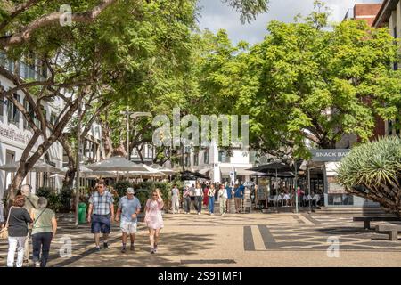 I turisti camminano lungo la strada alberata Rua Dr Antonio Jose De Almeida, Funchal Madeira, Portogallo, strada pedonale con bar e caffetterie Foto Stock