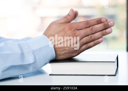 Mani che pregano con biblie, implorano un uomo d'affari insieme in preghiera o chiedono aiuto e assistenza. Sperando e desiderando un'opportunità, un BL Foto Stock
