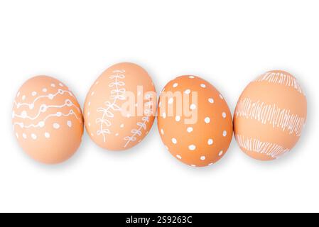 Uova di Pasqua marroni naturali con motivi bianchi minimalisti (cuori, punti e linee) isolate su uno sfondo bianco Foto Stock