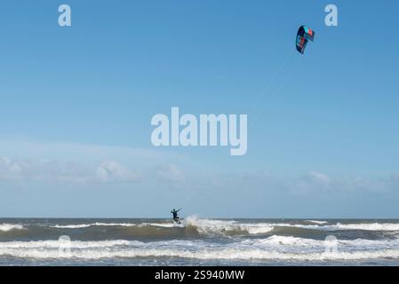 Azione dinamica di kite surf sopra le onde dell'oceano in una giornata luminosa Foto Stock