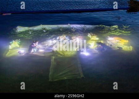 Lugano, Svizzera - 22 dicembre 2024: Il presepe sommerso illuminato nel lago di Lugano la sera Foto Stock