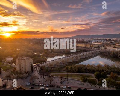 Vista aerea di Cordova, Spagna, con il colorato cielo del tramonto sul ponte romano, il centro medievale e la cattedrale Foto Stock