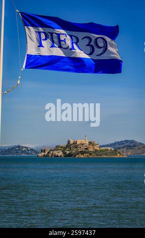 San Francisco, Stati Uniti - 30 aprile 2022: Bandiera del molo 39 con l'isola di Alcatraz sullo sfondo attraverso la baia, entrambe famose destinazioni turistiche Foto Stock