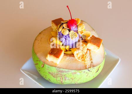 Buko halo, una varietà di halo-halo, un popolare dessert di ghiaccio rasato nelle Filippine servito in un fresco e giovane guscio di cocco Foto Stock