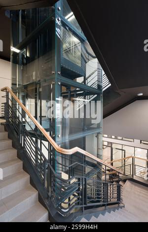 Moderno ascensore in vetro e design a scala a spirale Foto Stock