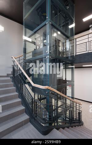 Moderno ascensore in vetro e design a scala a spirale Foto Stock