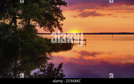 Splendido e romantico tramonto su un lago calmo Foto Stock