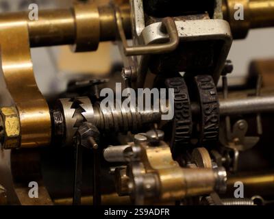 un primo piano dettagliato rivela gli intricati meccanismi in ottone e acciaio di una macchina da stampa d'epoca, sottolineando la consistenza e la qualità usurata del Foto Stock