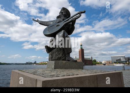 Stoccolma, Svezia, 2 agosto 2024: Statua di Evert Taube, il balladeer più amato della Svezia, situato sul lato dell'acqua di Riddarholmen a Stoccolma, Svezia. Foto Stock