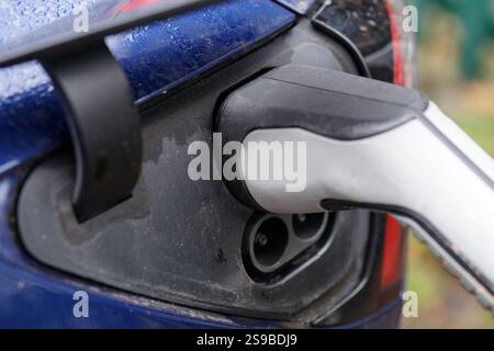 Una spina di tipo 2 collegata a un'auto elettrica. Il connettore maschio di tipo 2 offre spazio per tre conduttori di alimentazione ed è lo standard nell'UE dal 2013. Foto Stock