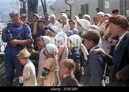La popolazione locale a guardare i soldati tedeschi di acqua di riempimento di bottiglie in Iugoslavia nell'aprile 1941 durante il WW2 invasione tedesca della Jugoslavia. Questa immagine è stata presa da un ufficiale dell'esercito tedesco/soldier tra 14 - 18/4/1941 in Iugoslavia. Foto Stock