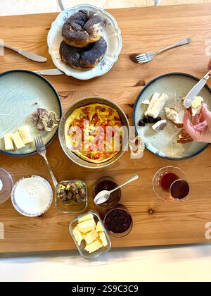 Tavolo da colazione turco. Piatto di persone che prendono le mani dolci, verdure, verdure, olive, formaggi, uova fritte, spezie, marmellate, miele, tè a coppe Foto Stock