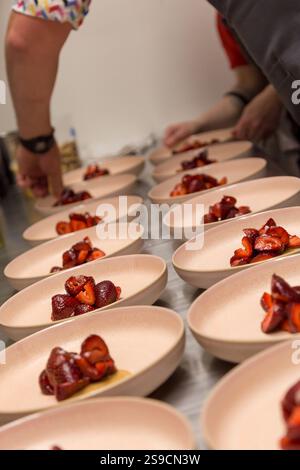 Dessert alla fragola accuratamente preparati su piatti singoli in una cucina professionale, Fog Lark Foto Stock