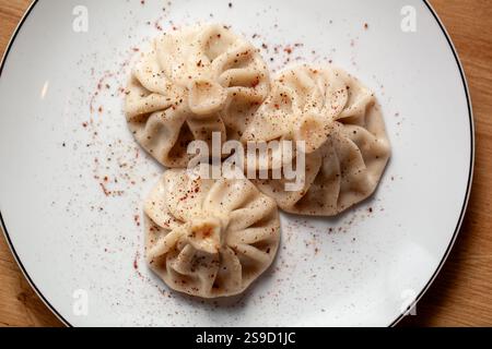 Tre gnocchi di khinkali sul piatto Foto Stock