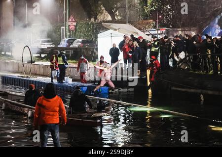 Milano, la storica nuotata notturna del Cimento Invernale organizzata da Canottieri San Cristoforo nelle acque ghiacciate del Naviglio grande a mezzanotte 130 anni dopo la prima edizione e dopo una pausa di 4 anni dovuta a Covid. Nella foto: Un momento di immersione nel canale Foto Stock