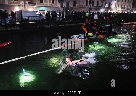 Milano, la storica nuotata notturna del Cimento Invernale organizzata da Canottieri San Cristoforo nelle acque ghiacciate del Naviglio grande a mezzanotte 130 anni dopo la prima edizione e dopo una pausa di 4 anni dovuta a Covid. Nella foto: Un momento di immersione nel canale Foto Stock