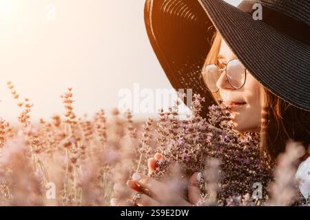 Donna in un campo di lavanda, che si gode il profumo Foto Stock