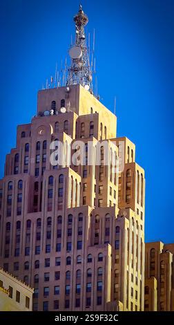 Un grattacielo architettonico art deco con facciate intricate e una distinta torre di trasmissione radio montata in cima, catturato durante la luce del giorno e set aga Foto Stock