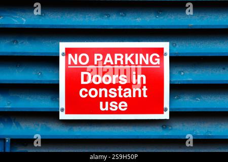 primo piano del cartello rosso di divieto di parcheggio su una porta blu con feritoie birmingham uk - porte in uso costante Foto Stock
