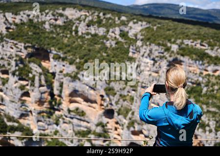 Donna che fotografa le pareti di un canyon nella Sierra de Guara da un punto di vista. Foto Stock