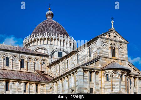 Una vista laterale del Duomo di Pisa in Italia, che mostra la sua architettura romanica con alternanza di marmo bianco e nero Foto Stock