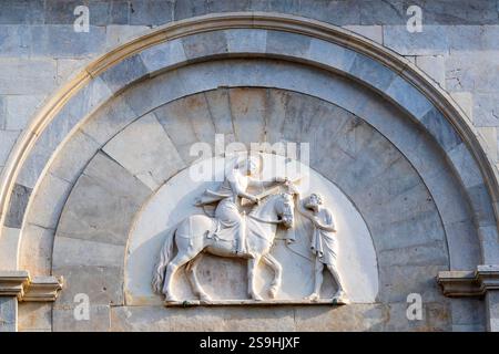 La lunetta sopra il portale principale della Parrocchia San Martino a Pisa presenta un bassorilievo del XIV secolo di Andrea Pisano raffigurante San Martino Foto Stock