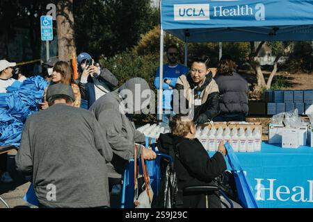 Pasadena, Stati Uniti. 25 gennaio 2025. Il personale di emergenza FEMA, insieme alle organizzazioni di volontariato, fornisce rifornimenti alle vittime degli incendi in California durante l'evento Dodgers Giveaway, 25 gennaio 2025, a Pasadena, California. Più di 16.000 strutture sono state distrutte negli incendi urbani che hanno spazzato attraverso la contea di Los Angeles. Crediti: Eduardo Martinez/FEMA Photo/Alamy Live News Foto Stock
