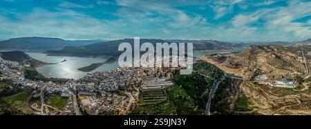 Vista aerea del bellissimo villaggio bianco di Iznajar in Andalusia, in Spagna, sopra un bacino idrico del fiume Genil con castello medievale Foto Stock