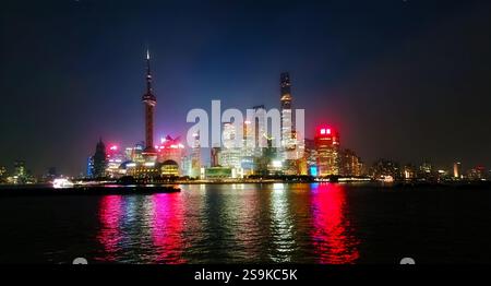 Shanghai, Cina - 01 gennaio 2025. Uno splendido paesaggio notturno di Shanghai, Cina, si riflette nelle acque scure del fiume Huangpu, che si staglia Foto Stock