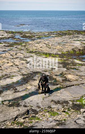 Frogman a piedi dal mare, città di Aberystwyth, Galles, luglio 2024 Foto Stock