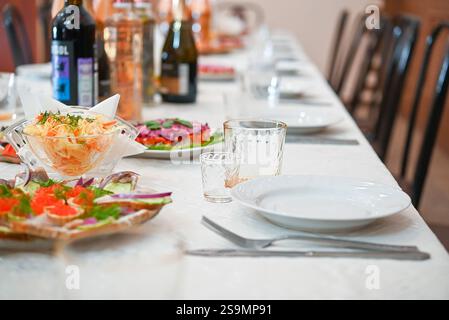 Un assortimento di deliziosi antipasti, antipasti e bevande sono splendidamente disposti su un tavolo con eleganti piatti bianchi e bicchieri scintillanti, Foto Stock