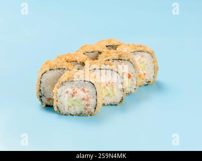 Fotografia in studio di Hot philadelphia roll con cetriolo e salmone avvolti in nori. Isolato su sfondo blu chiaro fisso. Sushi Perfection con involtino Hot tempura Foto Stock