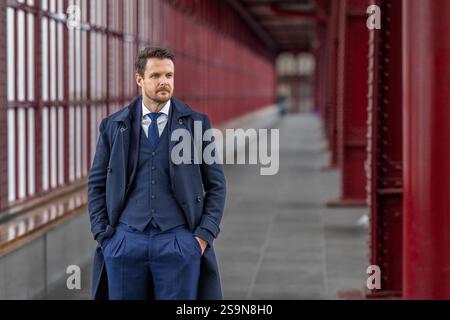 Dapper Gentleman in piedi con sicurezza su un sofisticato Walkway Foto Stock