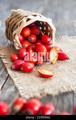 Anche di rose fresche mature in cesto su sacco di scasso, frutti di mora crudi o frutti di rosa di cane con semi, concetto di cibo sano ( rosa canina ) Foto Stock
