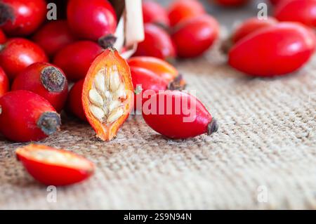 Anche di rose fresche mature in cesto su sacco di scasso, frutti di mora crudi o frutti di rosa di cane con semi, concetto di cibo sano ( rosa canina ) Foto Stock