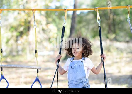 Un bambino in tuta regge le corde su un campo da gioco Foto Stock