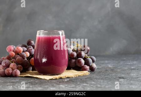Bicchiere di succo d'uva di frutta secca o rossa con uve fresche, concetto di bevanda fredda alla frutta biologica, colore originale Foto Stock