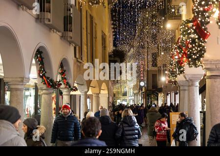 Lugano, Svizzera - 22 dicembre 2024: Una strada con luci natalizie e decorazioni natalizie, con gente che si gode la notte Foto Stock