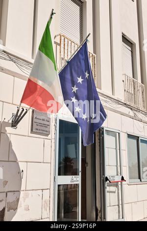 Civitavecchia, Italia, 27 gennaio 2025: Bandiere dell'Italia e dell'UE al di fuori di un ufficio governativo. Mostra le bandiere a Civitavecchia, in Italia, in evidenza Foto Stock