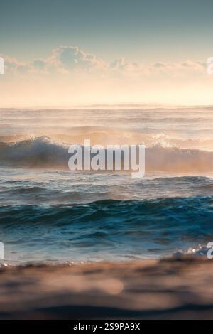 Splendide onde oceaniche catturate durante Un tramonto dorato su acque tranquille Foto Stock