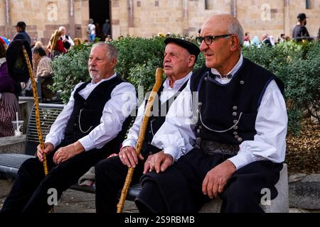 Tre vecchi vestiti tradizionalmente di fronte alla chiesa di Santa Maria di Montserrat a Tratalias Vecchio durante i processi della Madonna di Montserrat Foto Stock